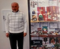 Борис Розин в русскоязычной библиотеке Денвера. В застеклённом шкафу выставка его судейских наград, а также книг, журналов и других изданий, в которых он публиковался. Фото 2014 г.