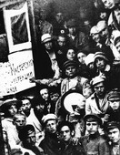 Фото сделано на витебском вокзале в момент отъезда УНОВИСа в Москву, с чёрным квадратом, помещённым на дверь вагона, и плакатом с приветствием для конференции художественных школ от Витебских мастерских. Малевич указывает на плакат и другой рукой удерживает круглую Супрему, по предположению некоторых исследователей сделанную для него Чашником. Илья Чашник на этом фото стоит по левую руку от Малевича, чуть ниже.